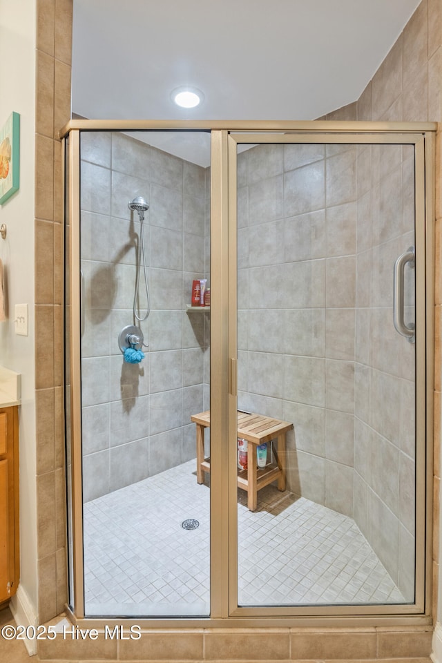 bathroom featuring walk in shower and vanity