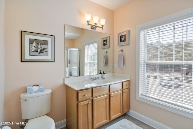 bathroom featuring vanity, an enclosed shower, and toilet