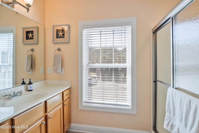 bathroom with plenty of natural light, an enclosed shower, and vanity