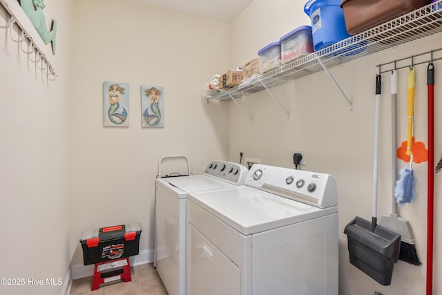 clothes washing area featuring light tile patterned floors and washer and clothes dryer