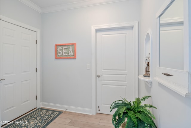 entrance foyer featuring ornamental molding and light wood-type flooring