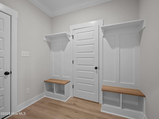 mudroom featuring light wood-style flooring, baseboards, and crown molding