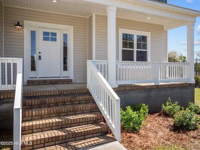 view of exterior entry featuring covered porch