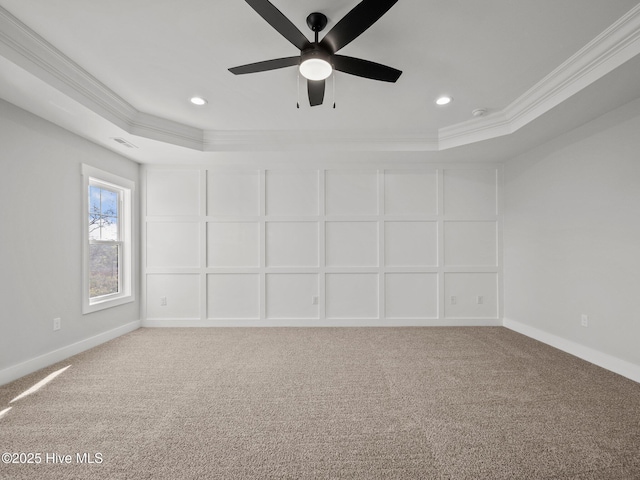 empty room featuring crown molding, a tray ceiling, and baseboards