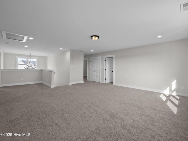 carpeted empty room with visible vents, baseboards, recessed lighting, and a chandelier