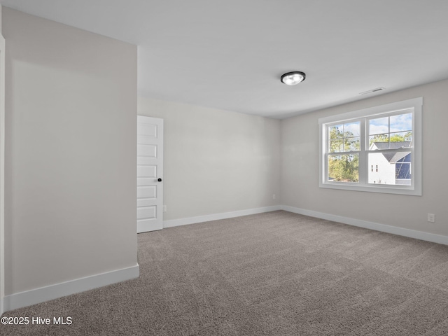 empty room featuring visible vents, baseboards, and carpet