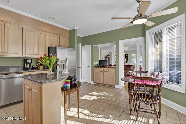 kitchen featuring dark stone countertops, stainless steel appliances, a center island, and light tile patterned floors