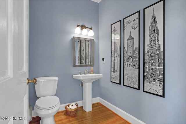 bathroom with hardwood / wood-style floors and toilet