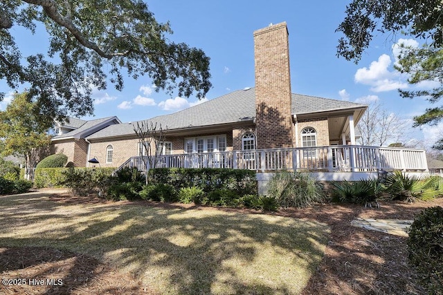 back of house with a wooden deck and a yard