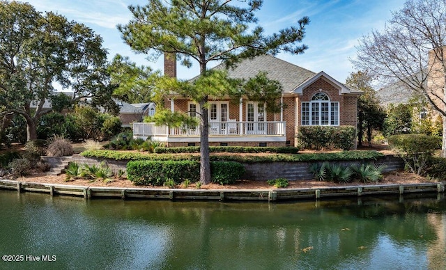 rear view of house with french doors and a water view