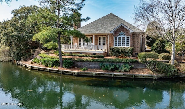 rear view of house featuring french doors and a water view