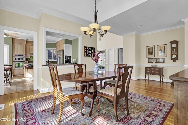 dining room featuring ornamental molding, ceiling fan with notable chandelier, and light wood-type flooring