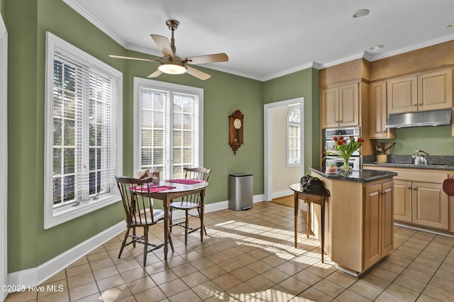 kitchen featuring a breakfast bar, light brown cabinetry, crown molding, a center island, and double oven