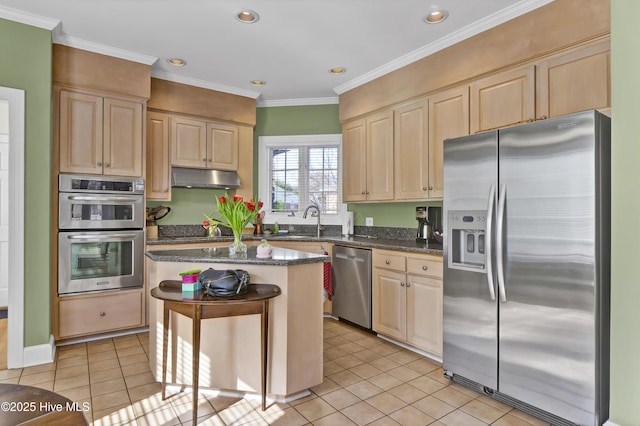 kitchen featuring dark stone countertops, light tile patterned floors, ornamental molding, appliances with stainless steel finishes, and a kitchen island