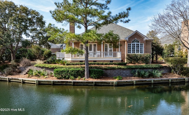 back of property featuring a water view and french doors