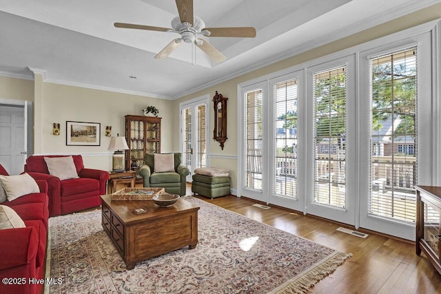 living room featuring crown molding, hardwood / wood-style floors, and ceiling fan