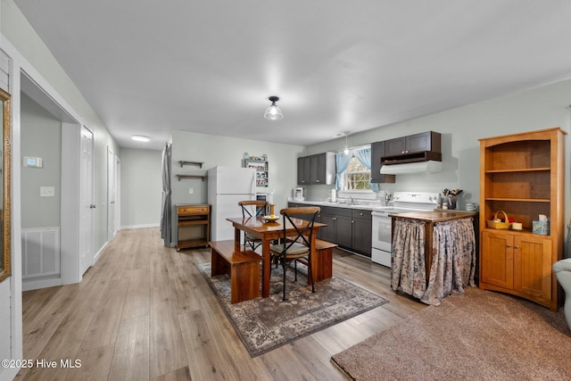 kitchen with white appliances, dark brown cabinets, and light wood-type flooring