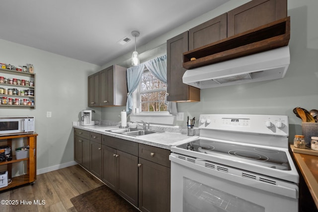 kitchen with pendant lighting, sink, white appliances, light hardwood / wood-style floors, and exhaust hood