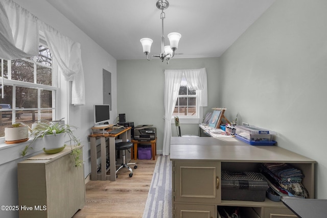 office area featuring light wood-type flooring and an inviting chandelier