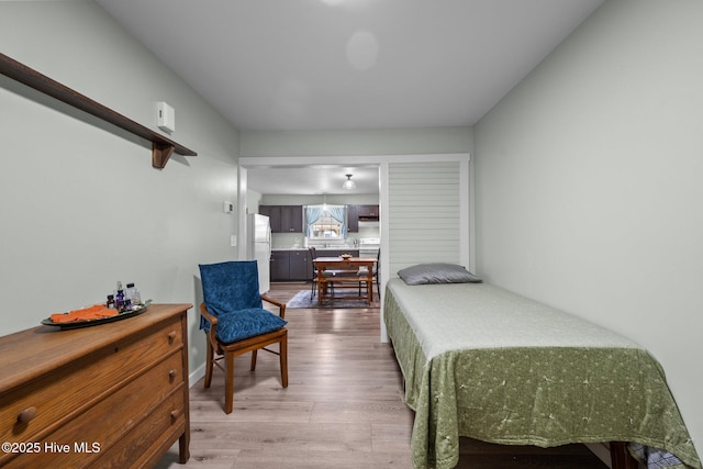 bedroom with white refrigerator and hardwood / wood-style flooring