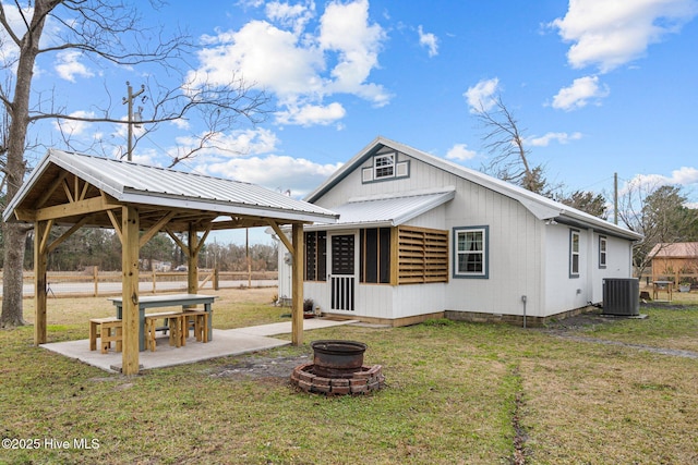 back of house featuring a patio, a fire pit, a yard, a gazebo, and central AC