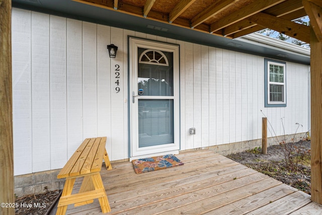 view of exterior entry featuring a wooden deck