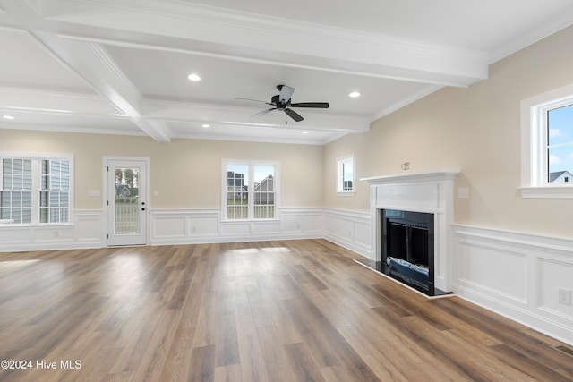 unfurnished living room with ceiling fan, plenty of natural light, beam ceiling, and hardwood / wood-style floors