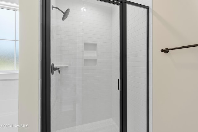 bathroom featuring a shower with door