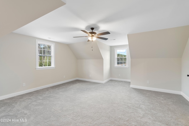 additional living space with lofted ceiling, light colored carpet, and ceiling fan