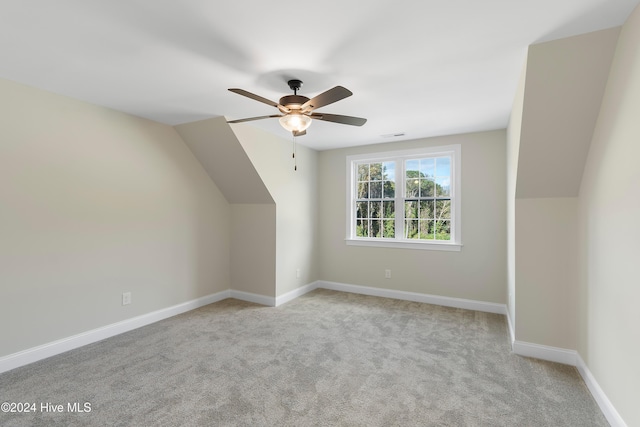 additional living space featuring vaulted ceiling, light colored carpet, and ceiling fan