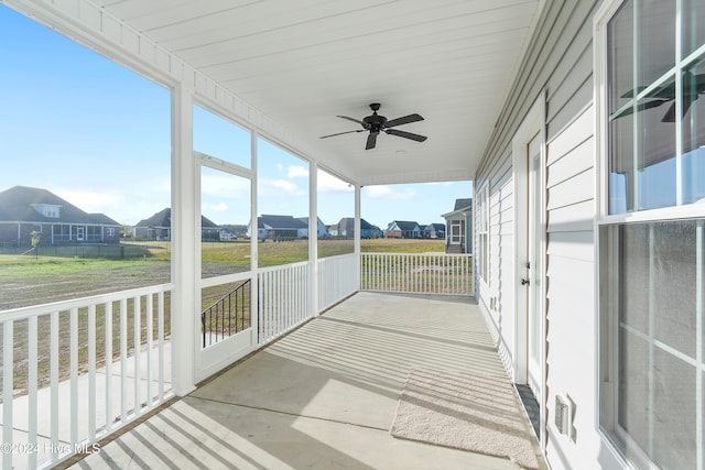 unfurnished sunroom with ceiling fan