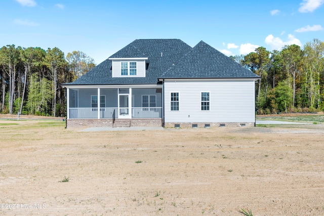 rear view of house featuring a sunroom and a lawn