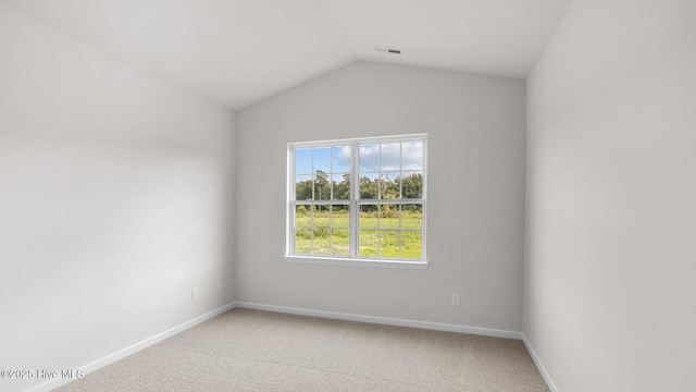 spare room with vaulted ceiling and carpet