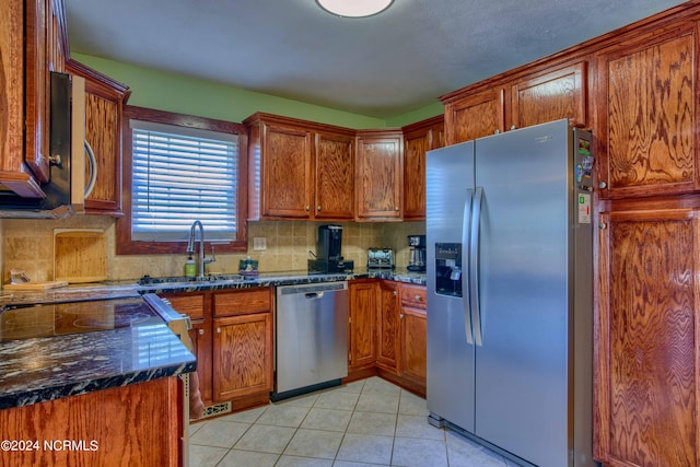1981 New River Inlet Rd, North Topsail Beach, NC 28460 - kitchen with stainless steel appliances, brown cabinetry, decorative backsplash, and light tile patterned flooring