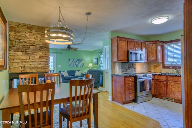 1981 New River Inlet Rd, North Topsail Beach, NC 28460 - kitchen featuring appliances with stainless steel finishes, a ceiling fan, decorative backsplash, open floor plan, and dark stone counters