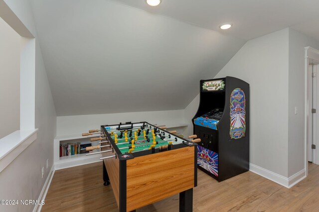 recreation room with hardwood / wood-style flooring and vaulted ceiling