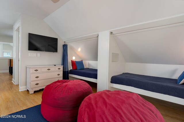 bedroom featuring lofted ceiling and light wood-type flooring