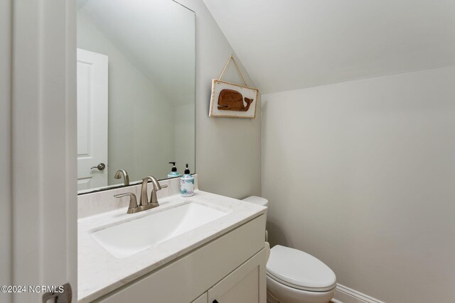 bathroom featuring vaulted ceiling, vanity, and toilet