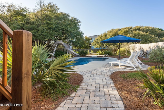 view of pool with a patio and a water slide