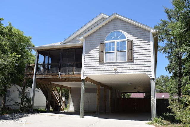 7304 E Oak Island Dr, Oak Island, NC 28465 - view of front of property with a carport, a sunroom, and driveway