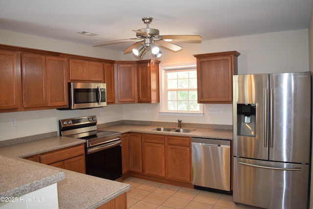 7304 E Oak Island Dr, Oak Island, NC 28465 - kitchen with stainless steel appliances, a sink, and brown cabinets