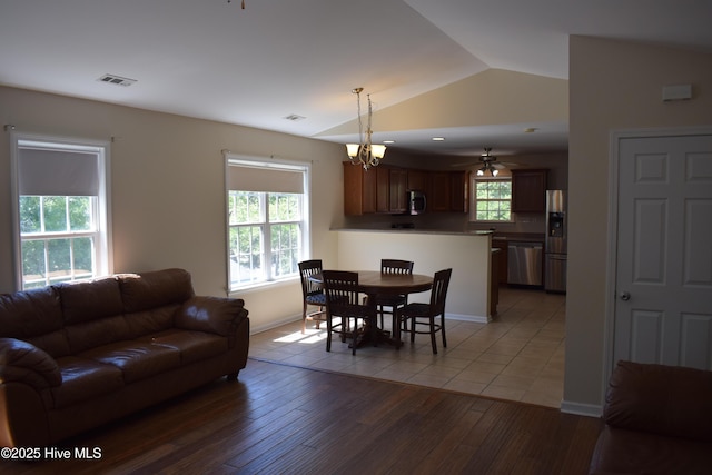 7304 E Oak Island Dr, Oak Island, NC 28465 - dining area with lofted ceiling, healthy amount of natural light, light wood-style flooring, a chandelier, and baseboards