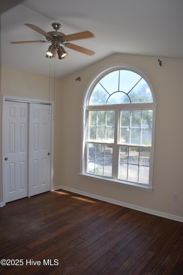 7304 E Oak Island Dr, Oak Island, NC 28465 - unfurnished bedroom featuring dark wood finished floors, a closet, baseboards, and a ceiling fan