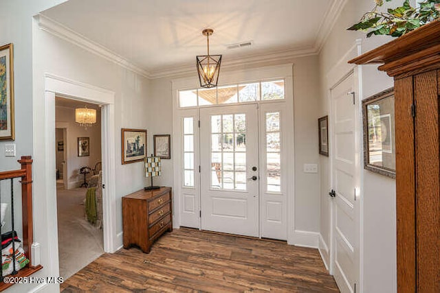 entrance foyer featuring a chandelier, crown molding, and dark wood-type flooring