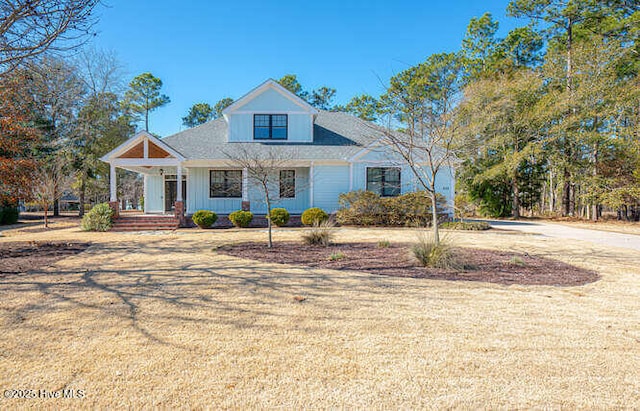 view of front of house featuring covered porch and a front yard