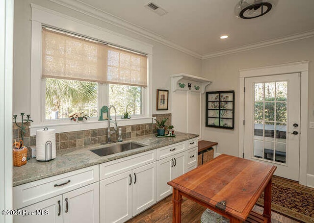 kitchen featuring a healthy amount of sunlight, white cabinetry, sink, and light stone counters