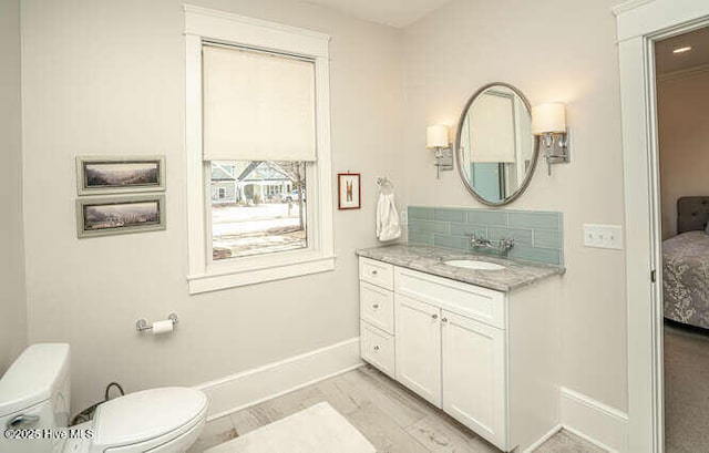 bathroom with wood-type flooring, vanity, and toilet