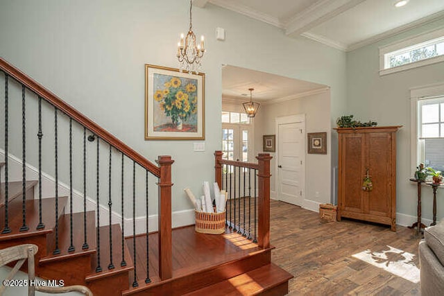 foyer entrance with hardwood / wood-style floors, crown molding, an inviting chandelier, and beamed ceiling