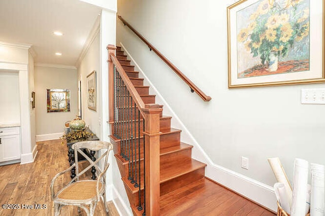 stairway featuring crown molding and hardwood / wood-style floors