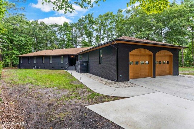 ranch-style home featuring a garage and a front lawn